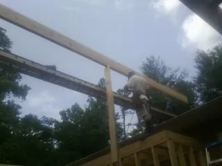 Carpenter setting a ridge beam over a new addition frame — Ice Dam Removal by Roofing Brothers in Cokato
