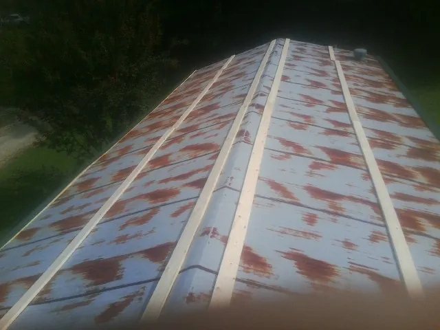 Rusted metal roof panels with new wood purlins before replacement — Storm Damage Roof Repair in Cokato by Roofing Brothers