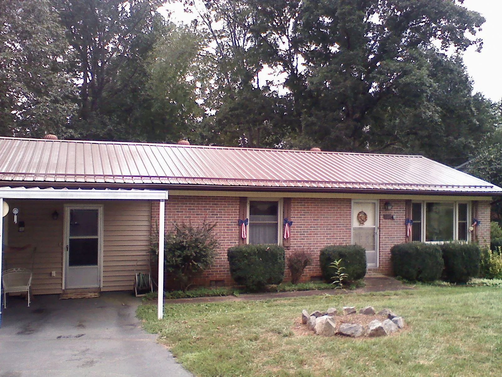 Bronze metal roof and carport on a brick ranch home — Roof Repair work by our crew in Cokato